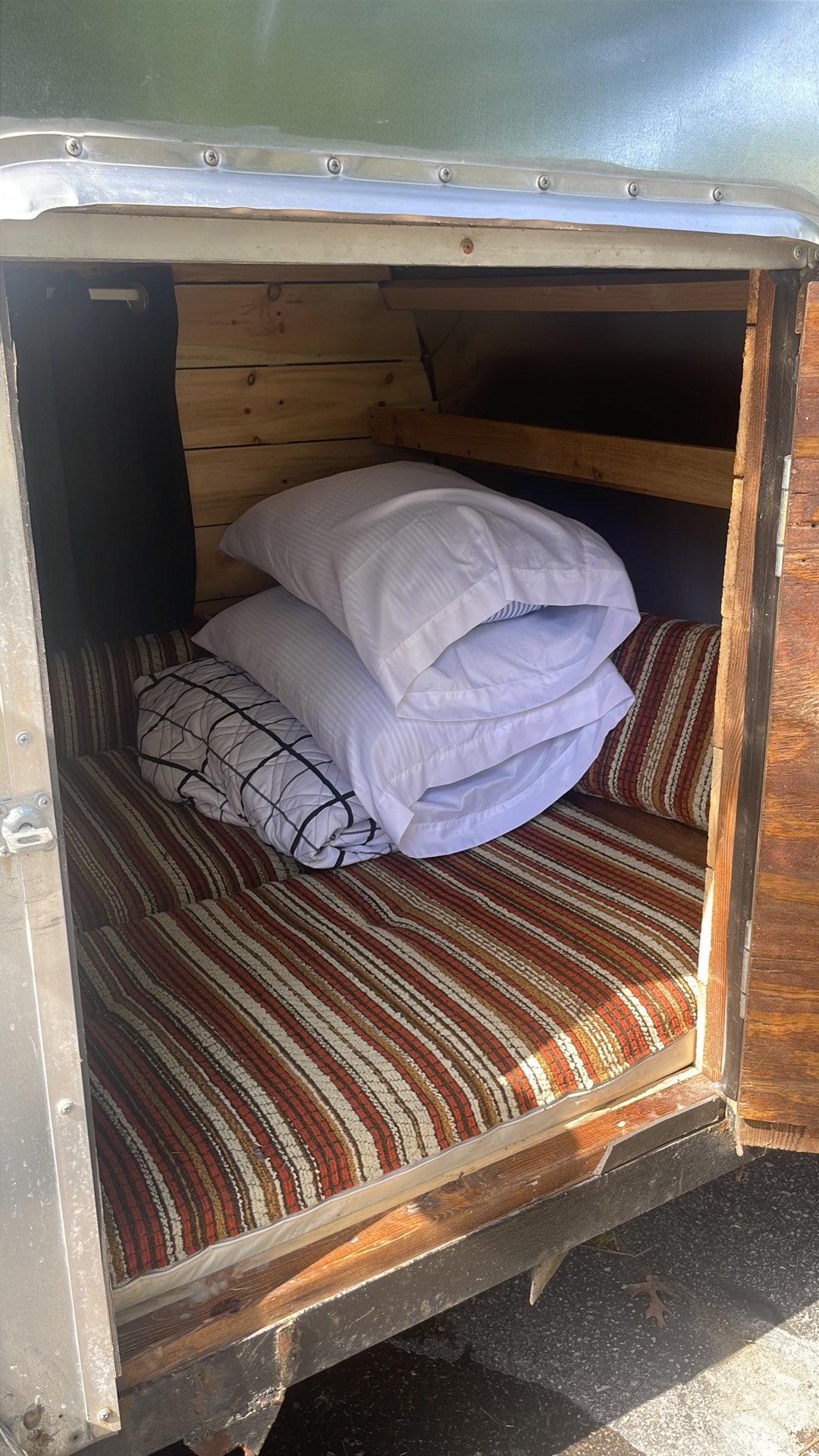 Bed made up with fresh bedding, seen through the side door