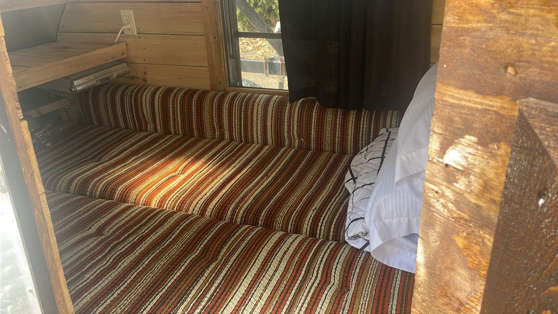 Sleeping area with side window, curtains, and pillows
